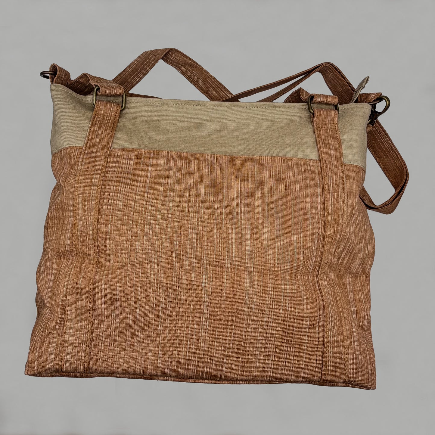 Brown textured bag with beige top section on a gray background