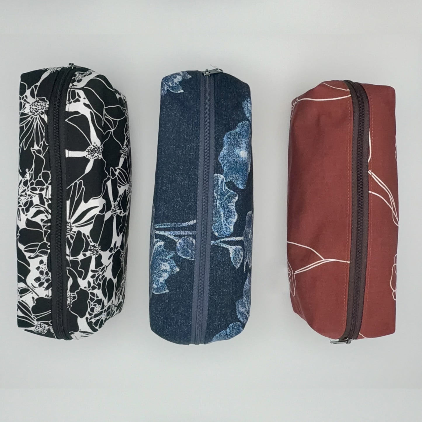 Three fabric pouches with floral patterns on a white background