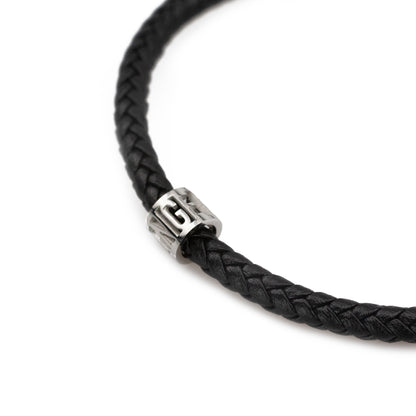 Black braided cord bracelet with a silver clasp on a white background