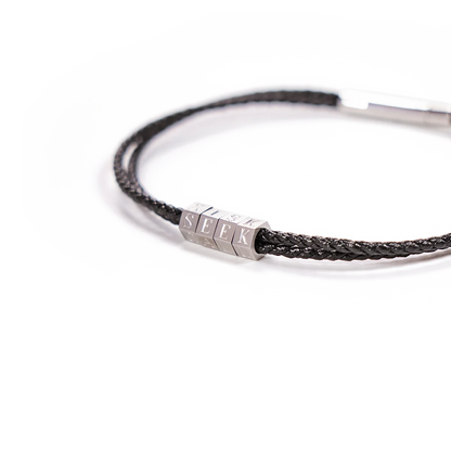 Bracelet with braided design and hexagonal metal tag on a white background