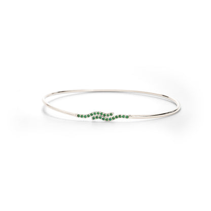 Silver bangle with green stones on a white background