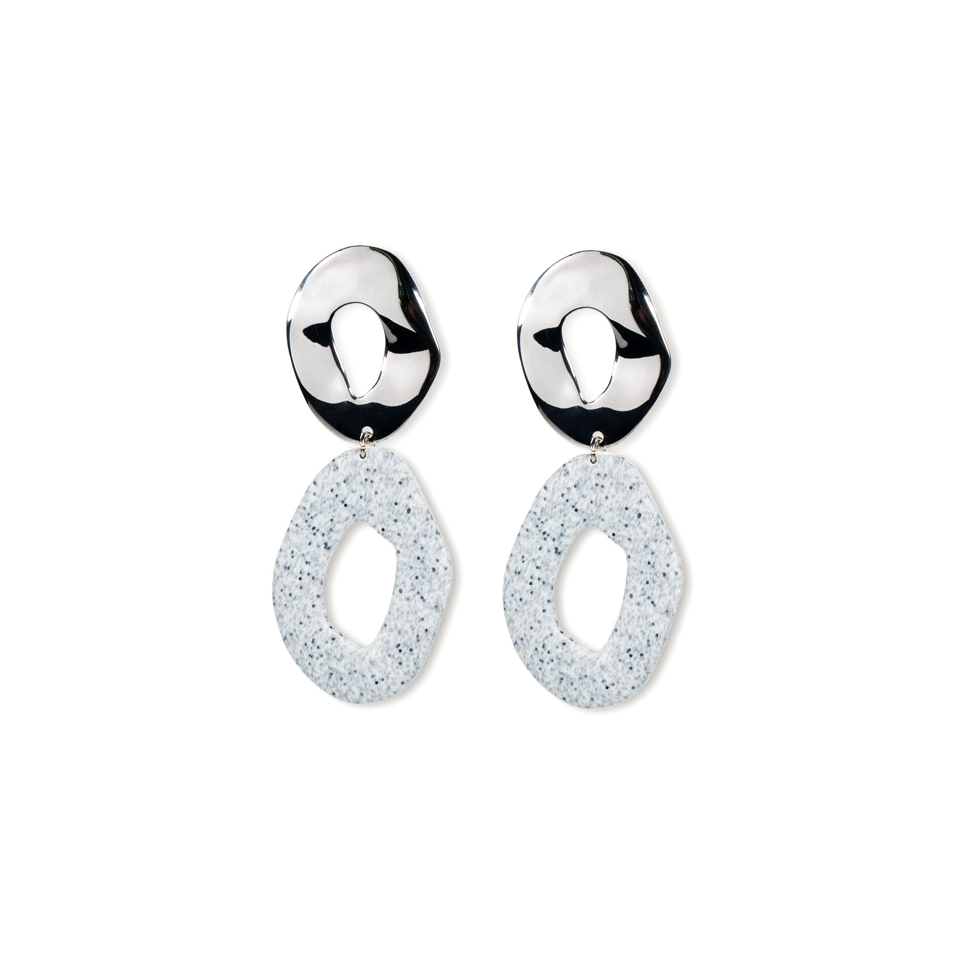 Pair of silver earrings with white speckled drops on a white background