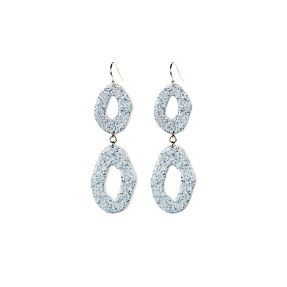 Pair of glittery silver earrings on a white background