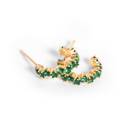 Gold hoop earrings with green gemstones on a white background