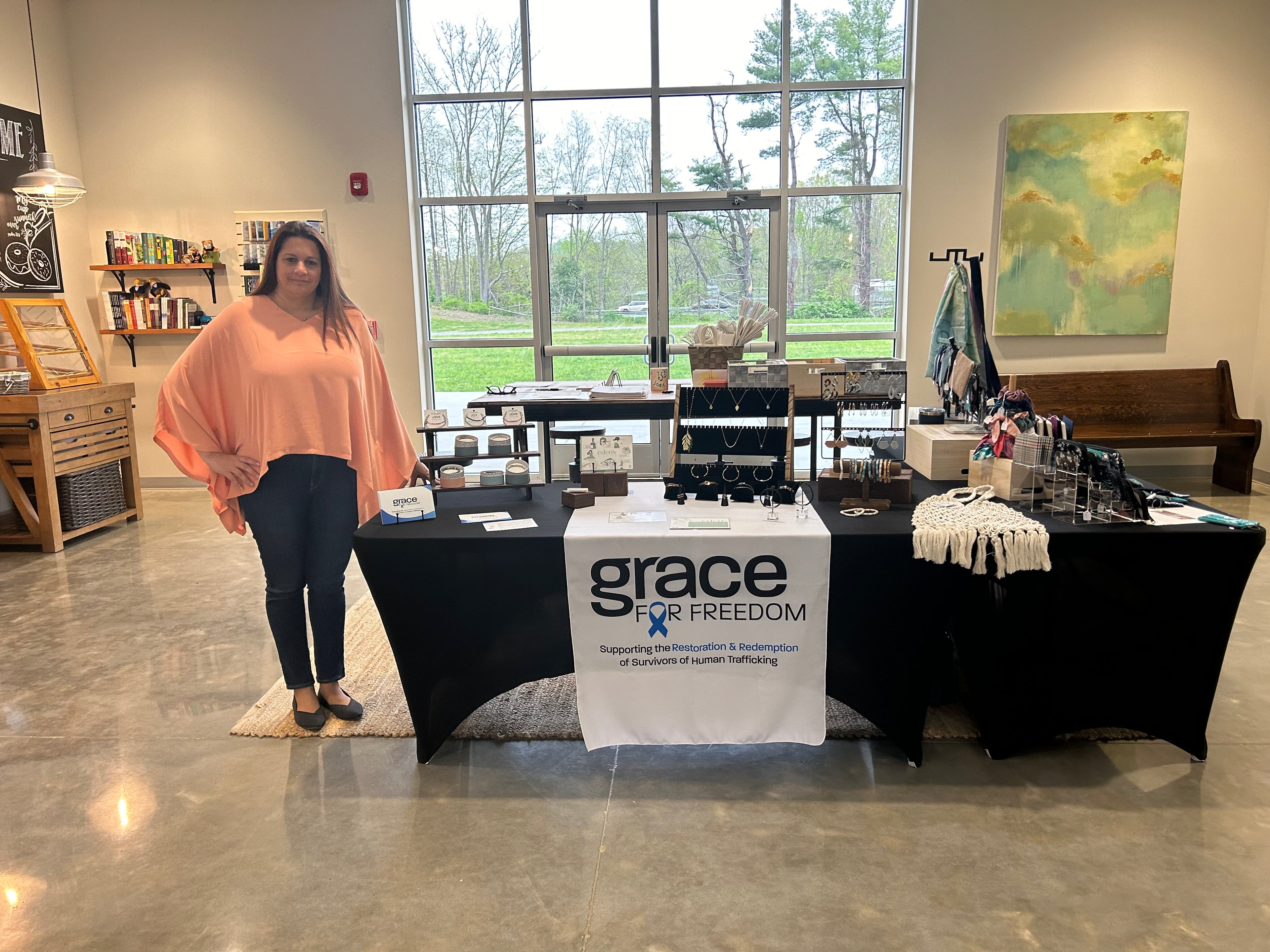 photo with woman standing next to table with products