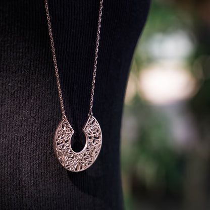 Necklace with a detailed pendant on a black background
