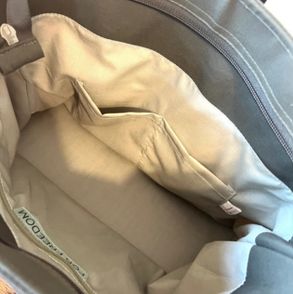 Close-up of a beige pillow inside a gray bag with a visible brand label.