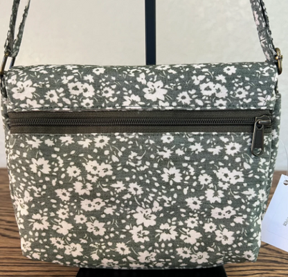 Floral patterned handbag with a visible brand tag on a neutral background