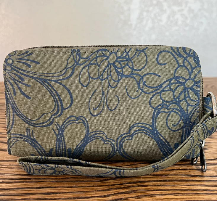 Floral patterned clutch bag on a wooden surface with a neutral background