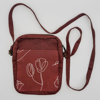 Brown crossbody bag with floral design on a white background
