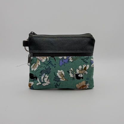 Floral-patterned pouch with a black zipper on a gray background
