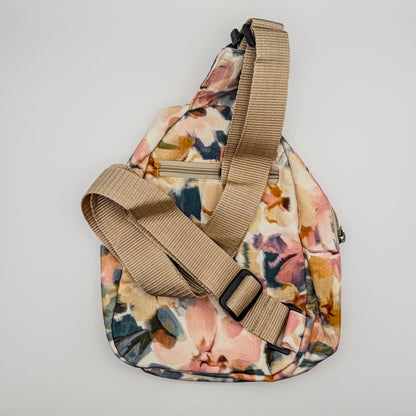 Floral-patterned sling bag with a beige strap on a light gray background