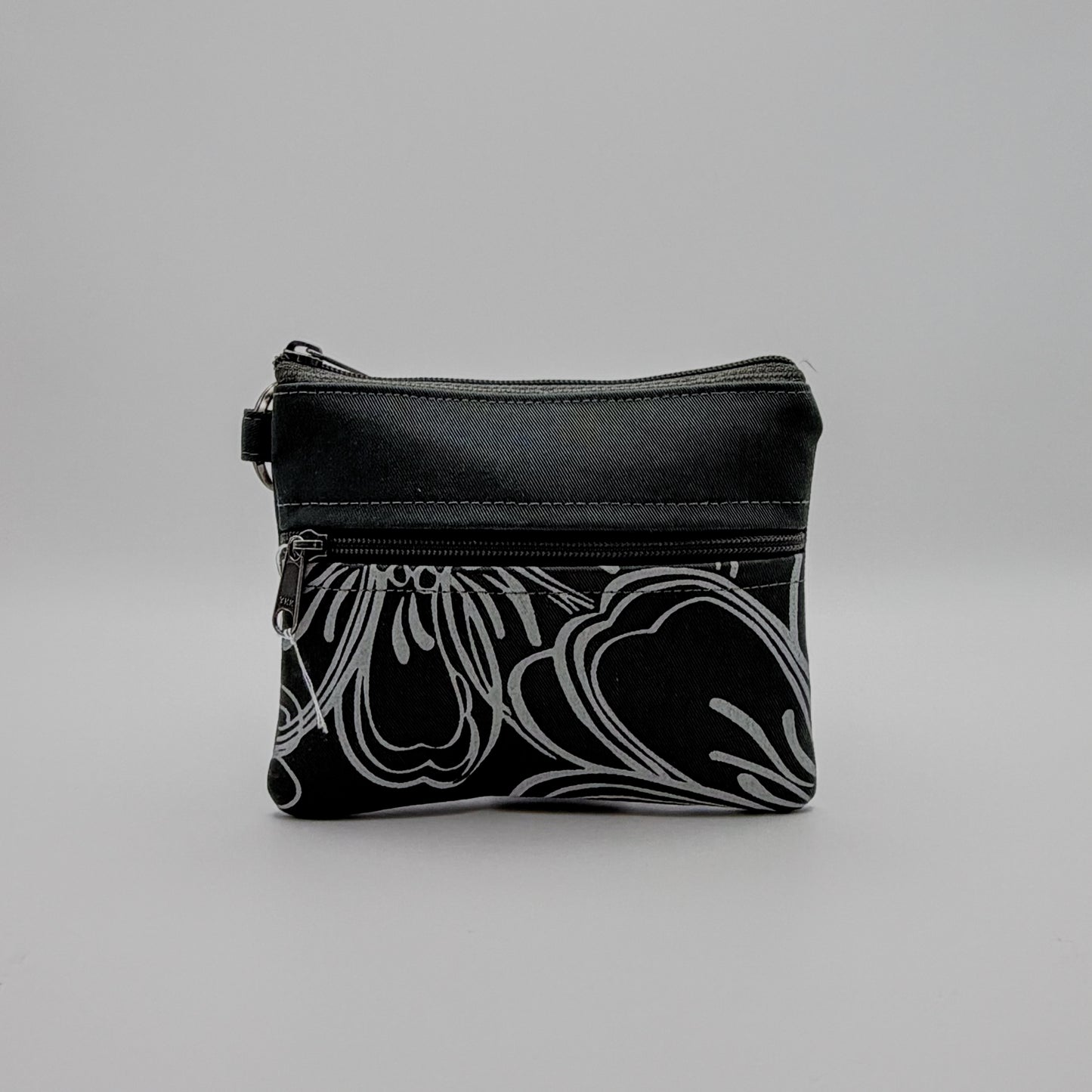 Black pouch with white floral pattern on a gray background