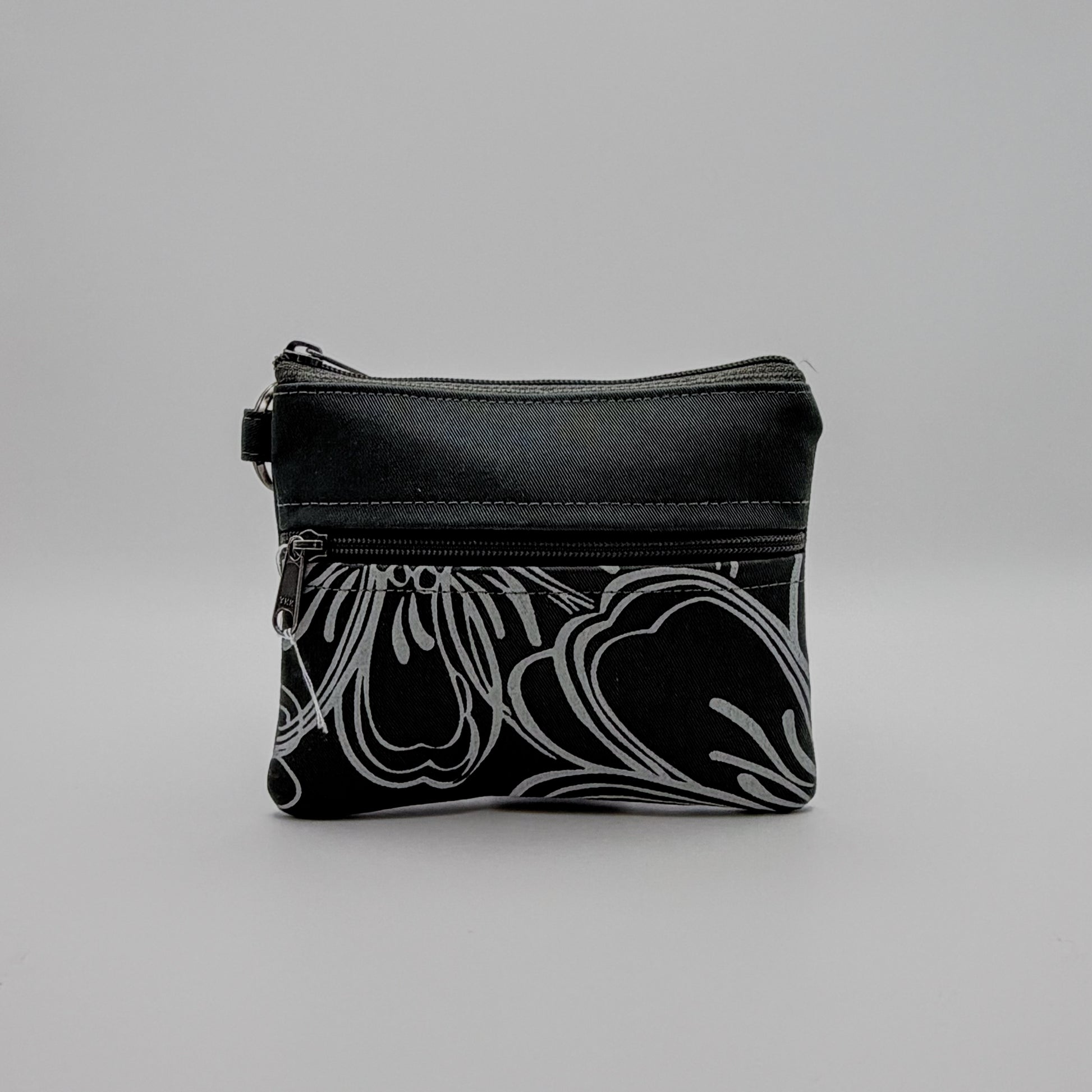 Black pouch with white floral pattern on a gray background