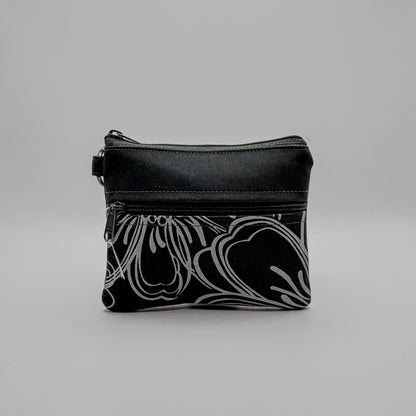 Black pouch with white floral pattern on a gray background