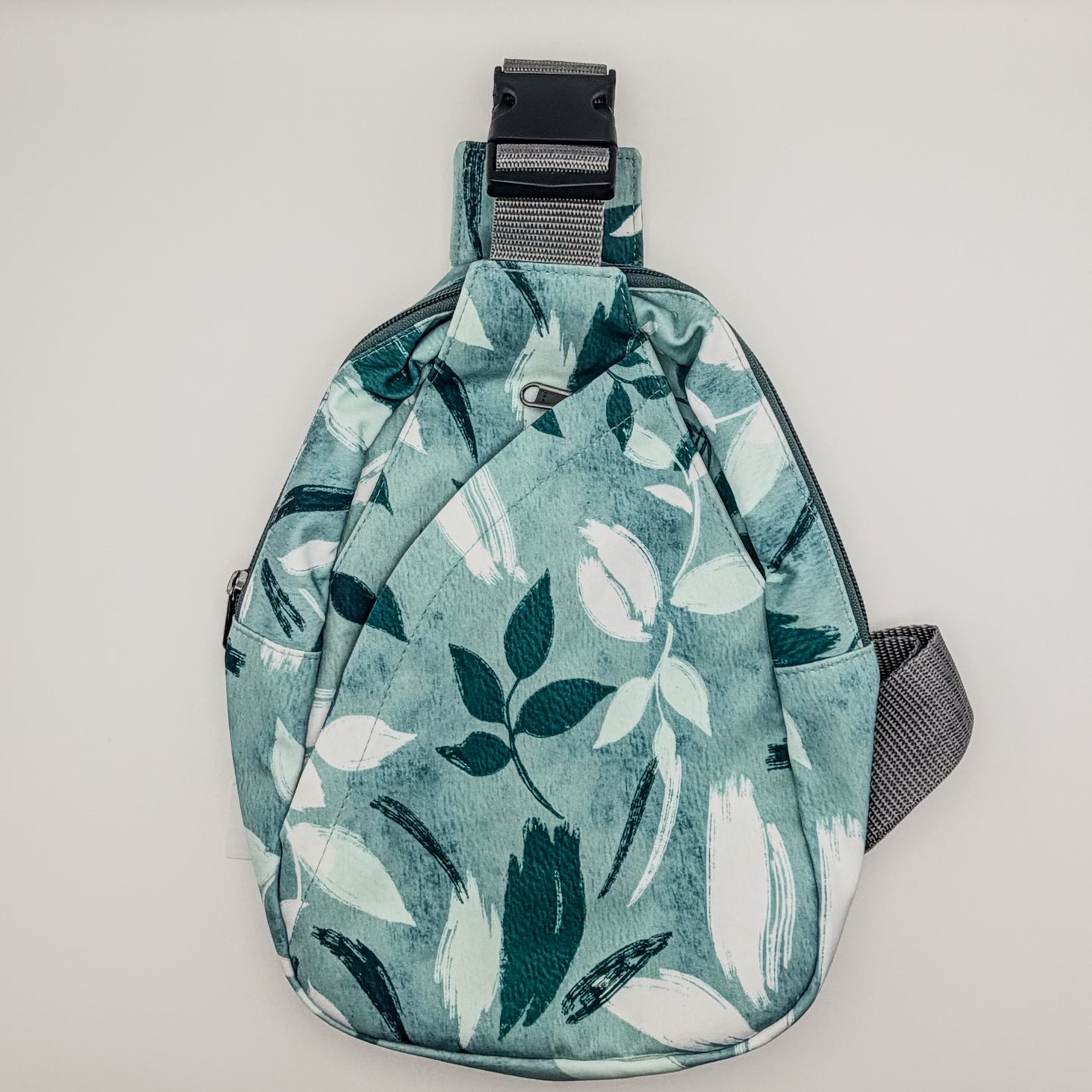 Sling bag with leaf pattern on a light gray background