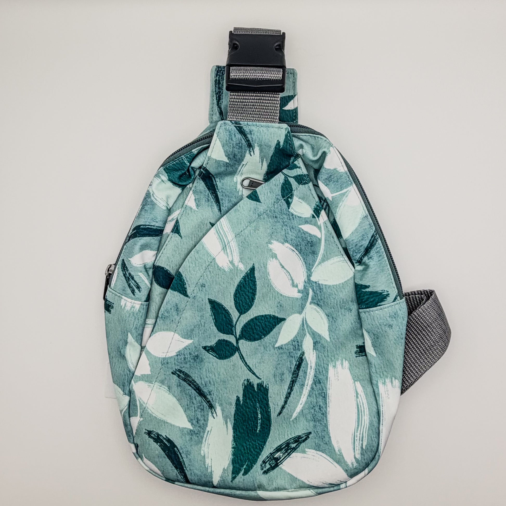 Sling bag with leaf pattern on a light gray background