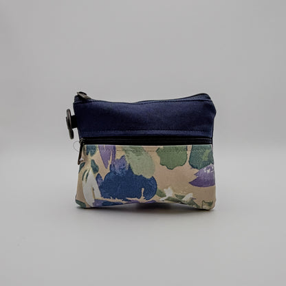 Floral-patterned pouch with a navy blue top section on a gray background