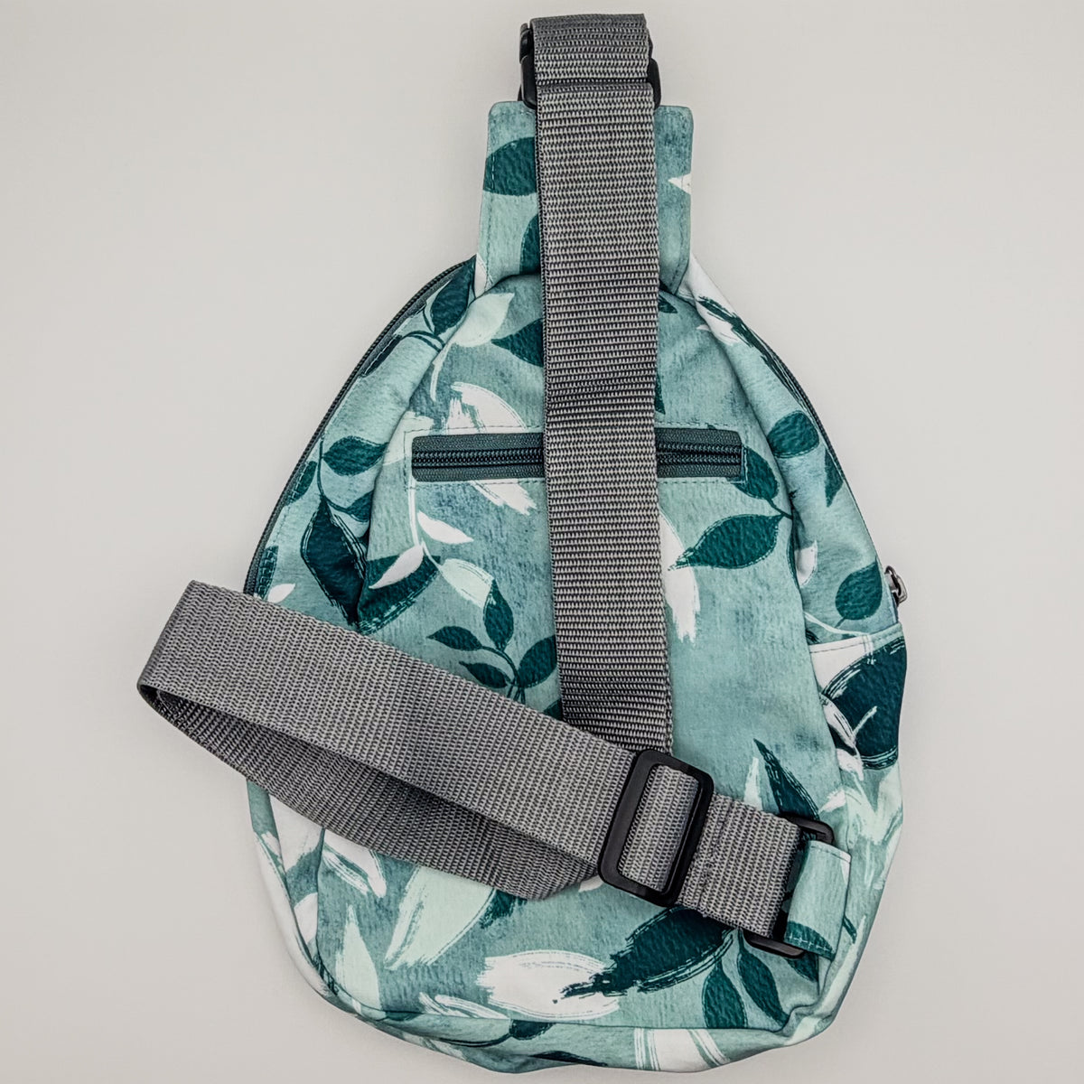 Sling bag with leaf pattern on a light gray background