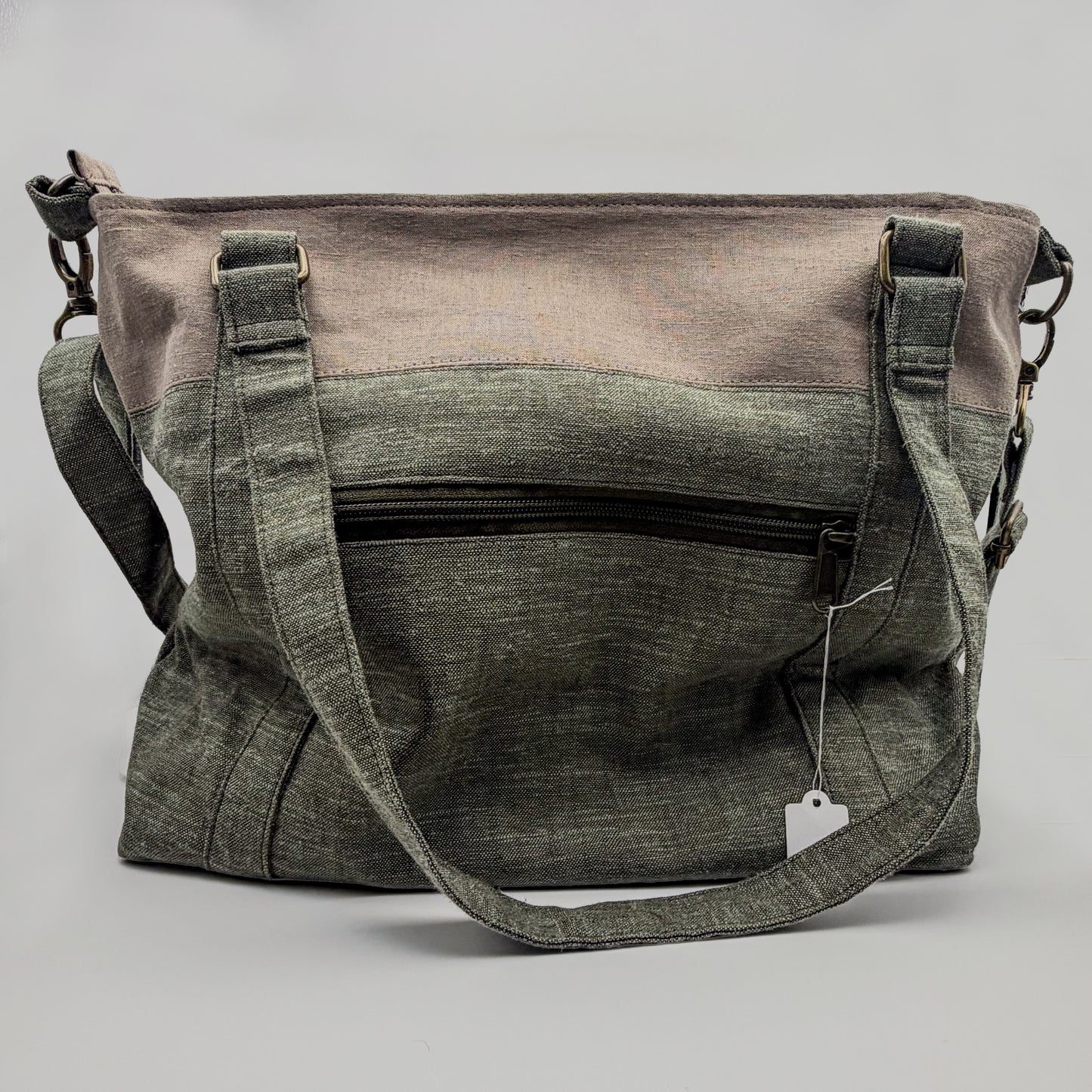 Gray and green bag with a visible brand tag on a gray background