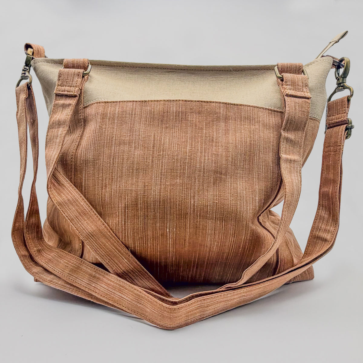 Brown leather bag with beige top section on a light gray background