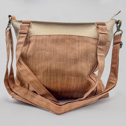 Brown leather bag with beige top section on a light gray background