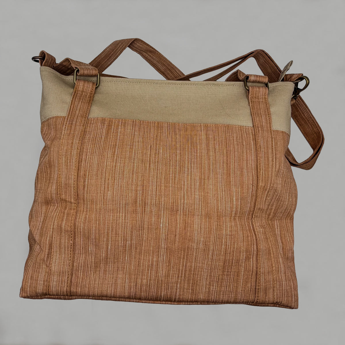 Brown textured bag with beige top section on a gray background