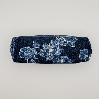 Navy pencil case with white floral pattern on a light gray background