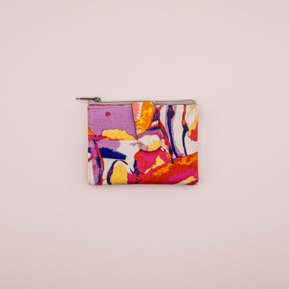 Colorful abstract-patterned pouch on a light beige background