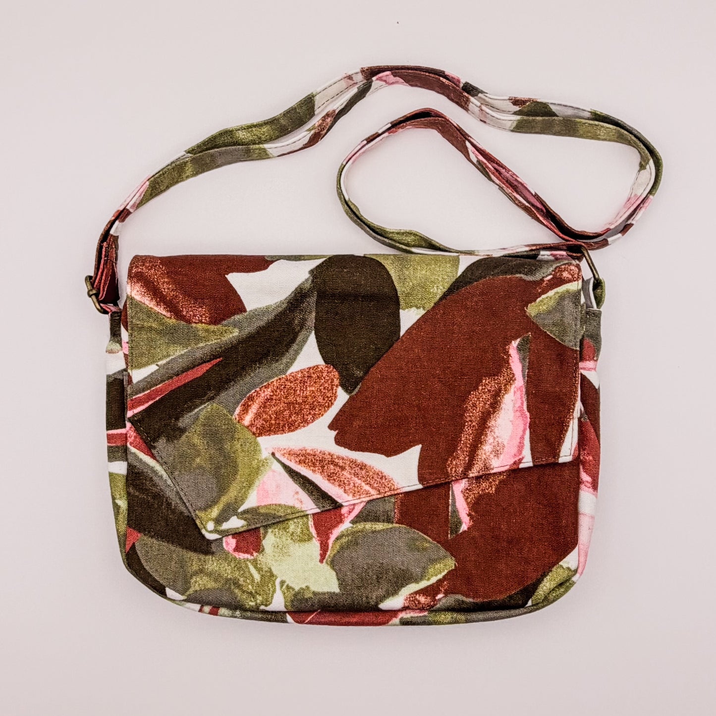 Floral patterned handbag with a strap on a light gray background