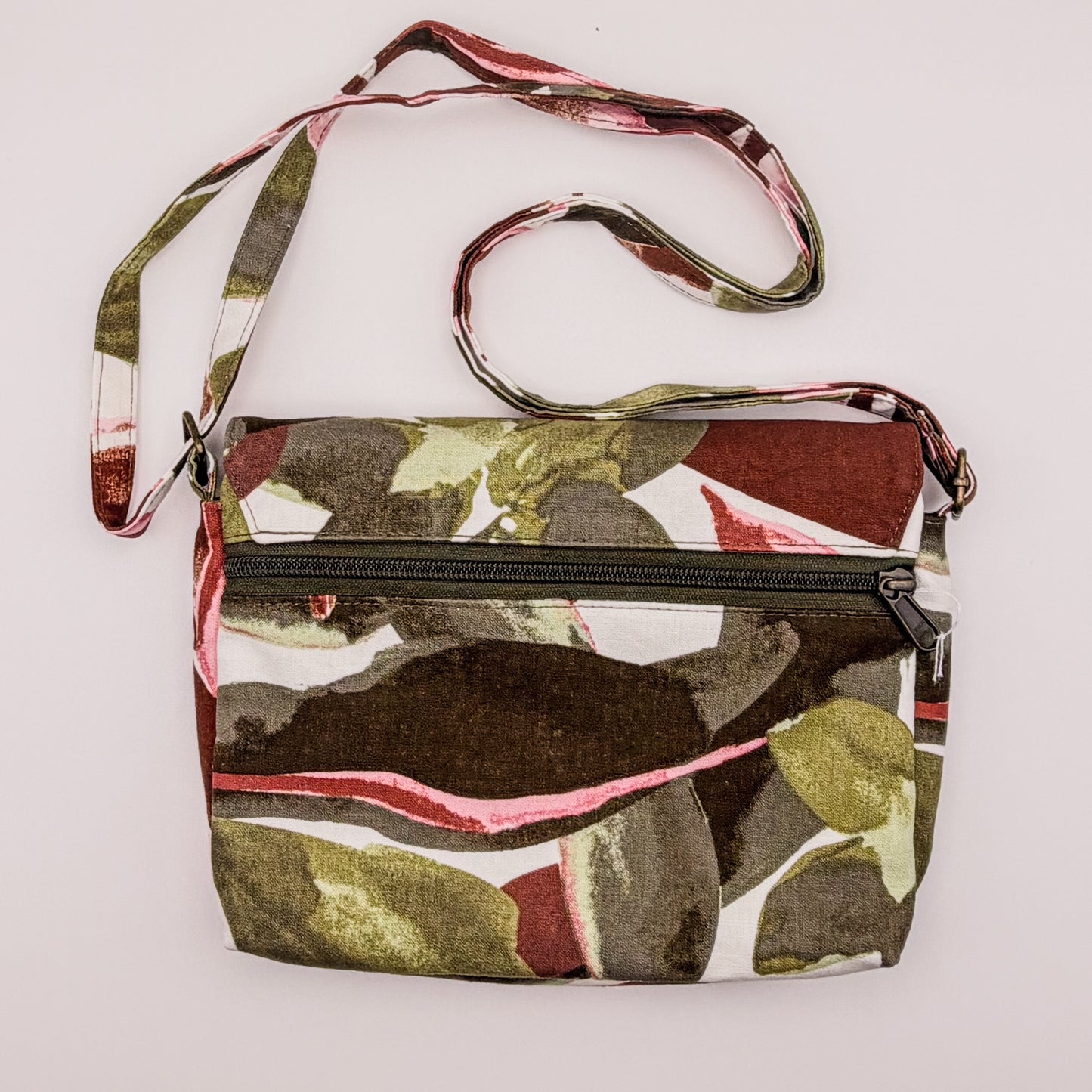 Camouflage-patterned crossbody bag with a strap on a white background