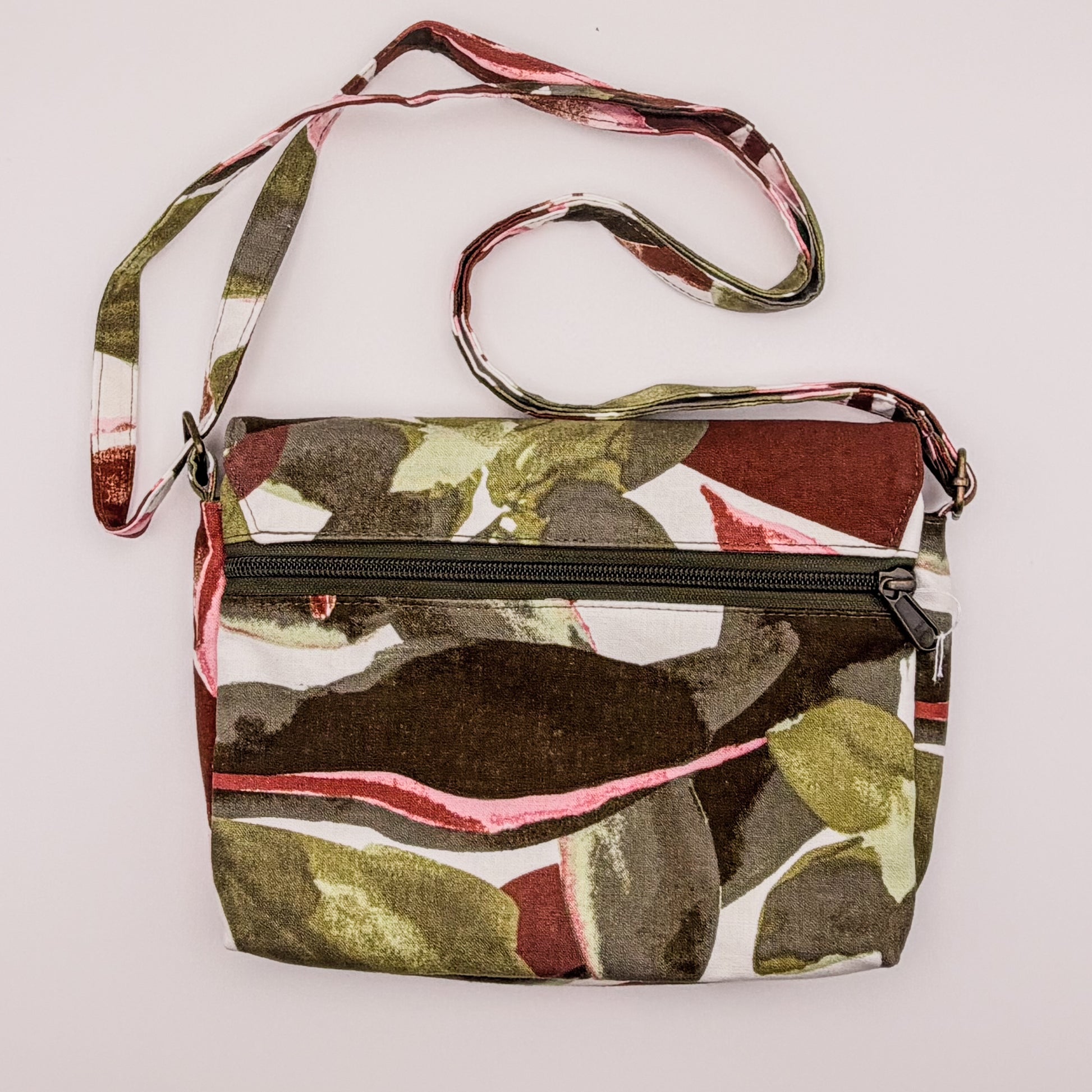 Camouflage-patterned crossbody bag with a strap on a white background