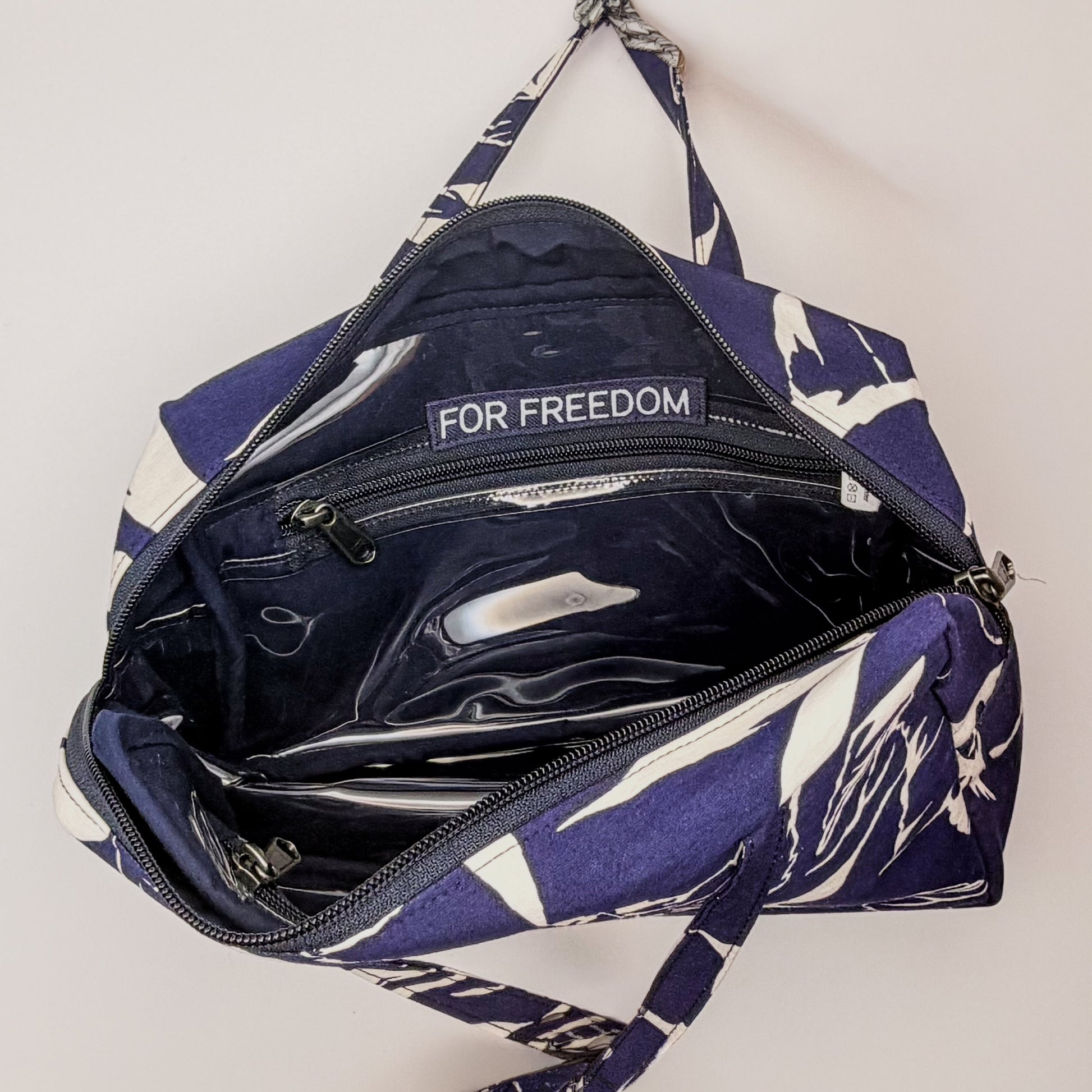 Navy blue bag with white floral pattern and 'For Freedom' text on a light gray background