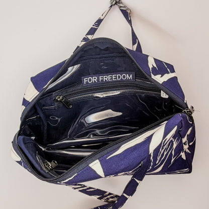 Navy blue bag with white floral pattern and 'For Freedom' text on a light gray background