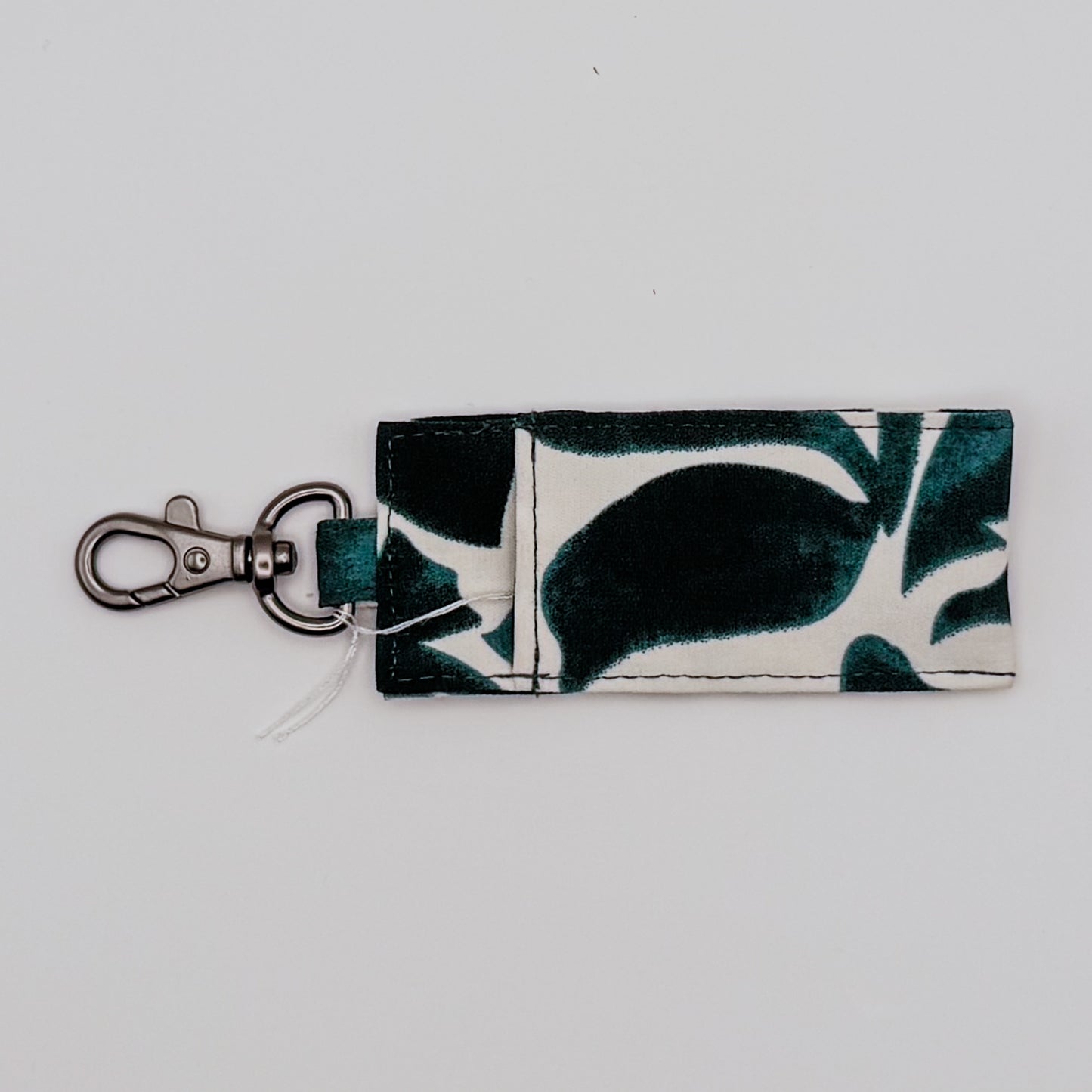 Keychain with a leaf pattern on a light gray background