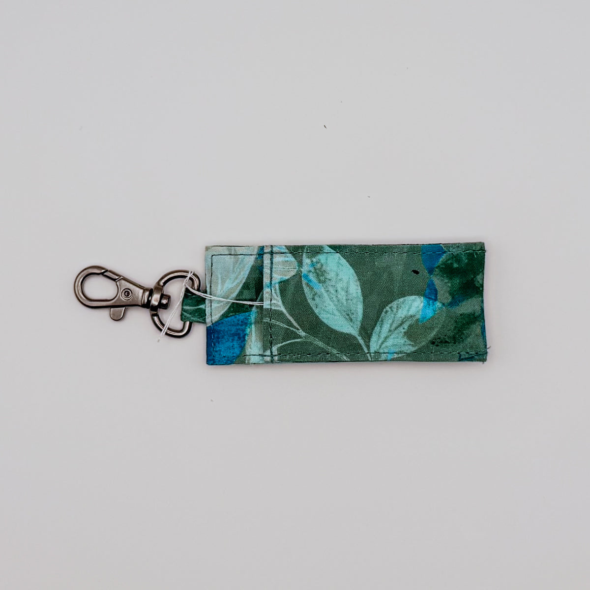 Fabric keychain with leaf pattern on a light gray background
