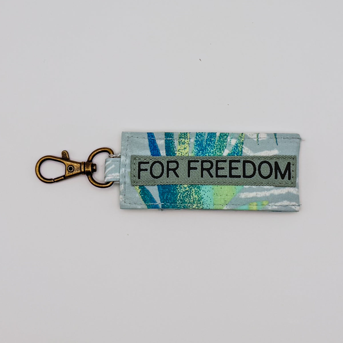 Keychain with 'FOR FREEDOM' text on a light gray background
