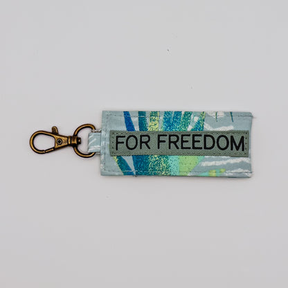 Keychain with 'FOR FREEDOM' text on a light gray background