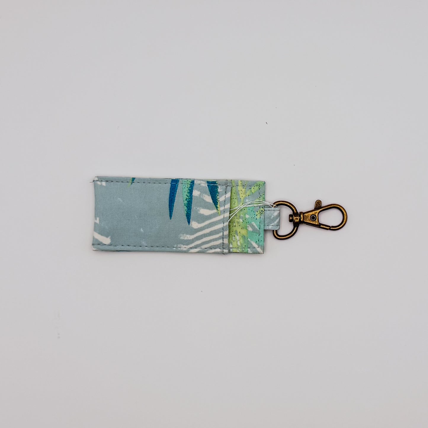 Fabric key fob with leaf pattern on a light gray background