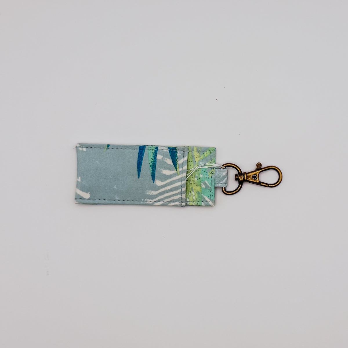 Fabric key fob with leaf pattern on a light gray background