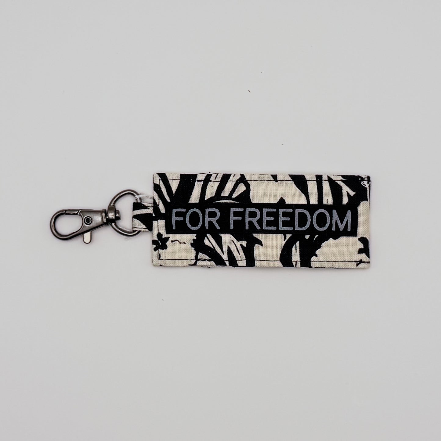 Keychain with 'FOR FREEDOM' text on a light gray background