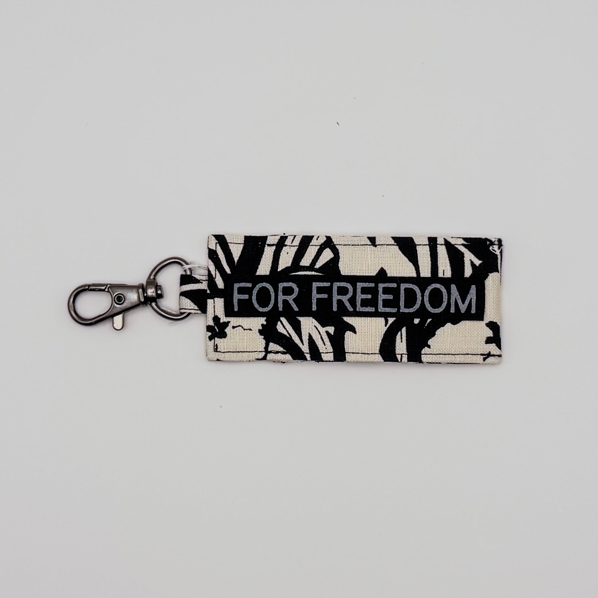 Keychain with 'FOR FREEDOM' text on a light gray background