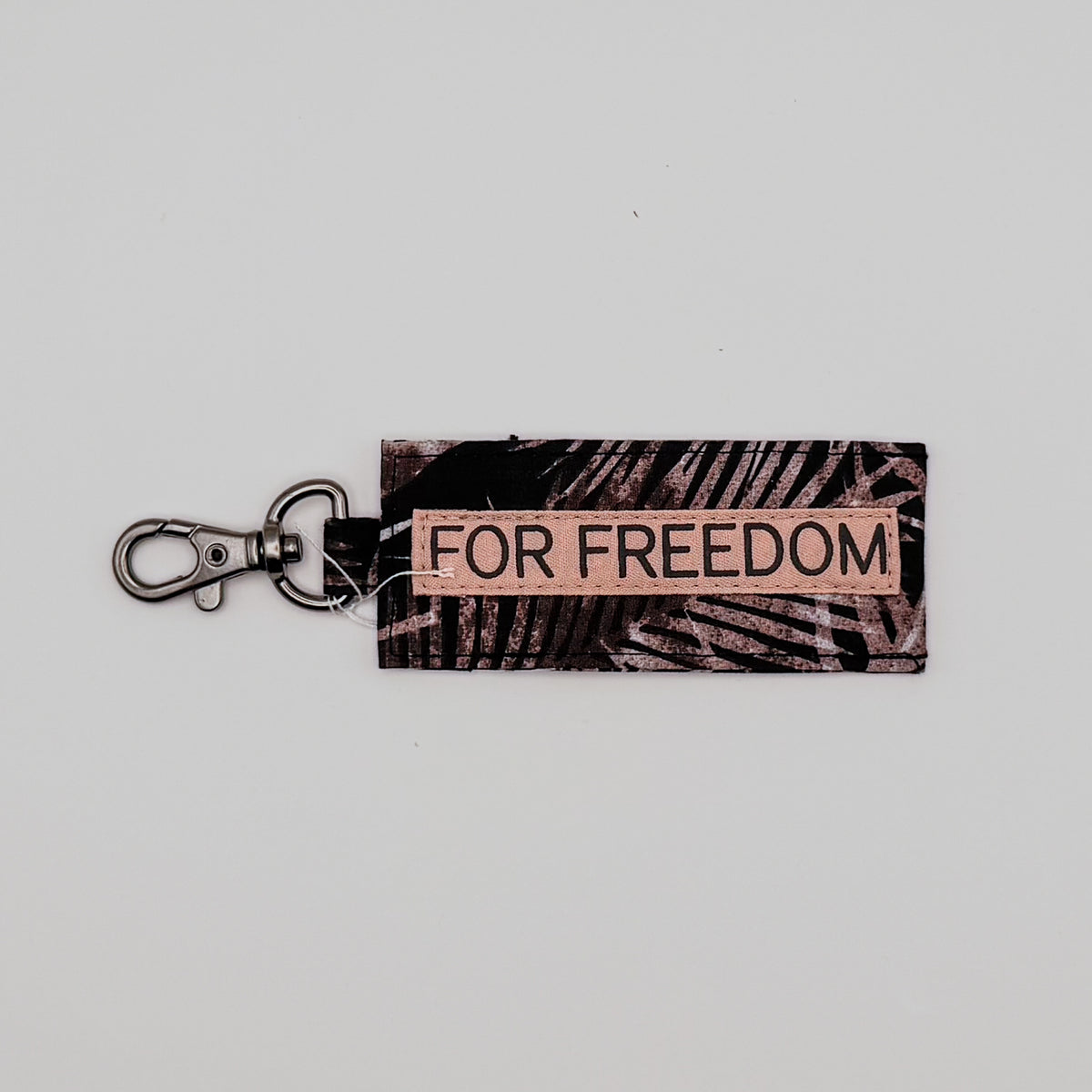 Keychain with 'FOR FREEDOM' label on a light gray background