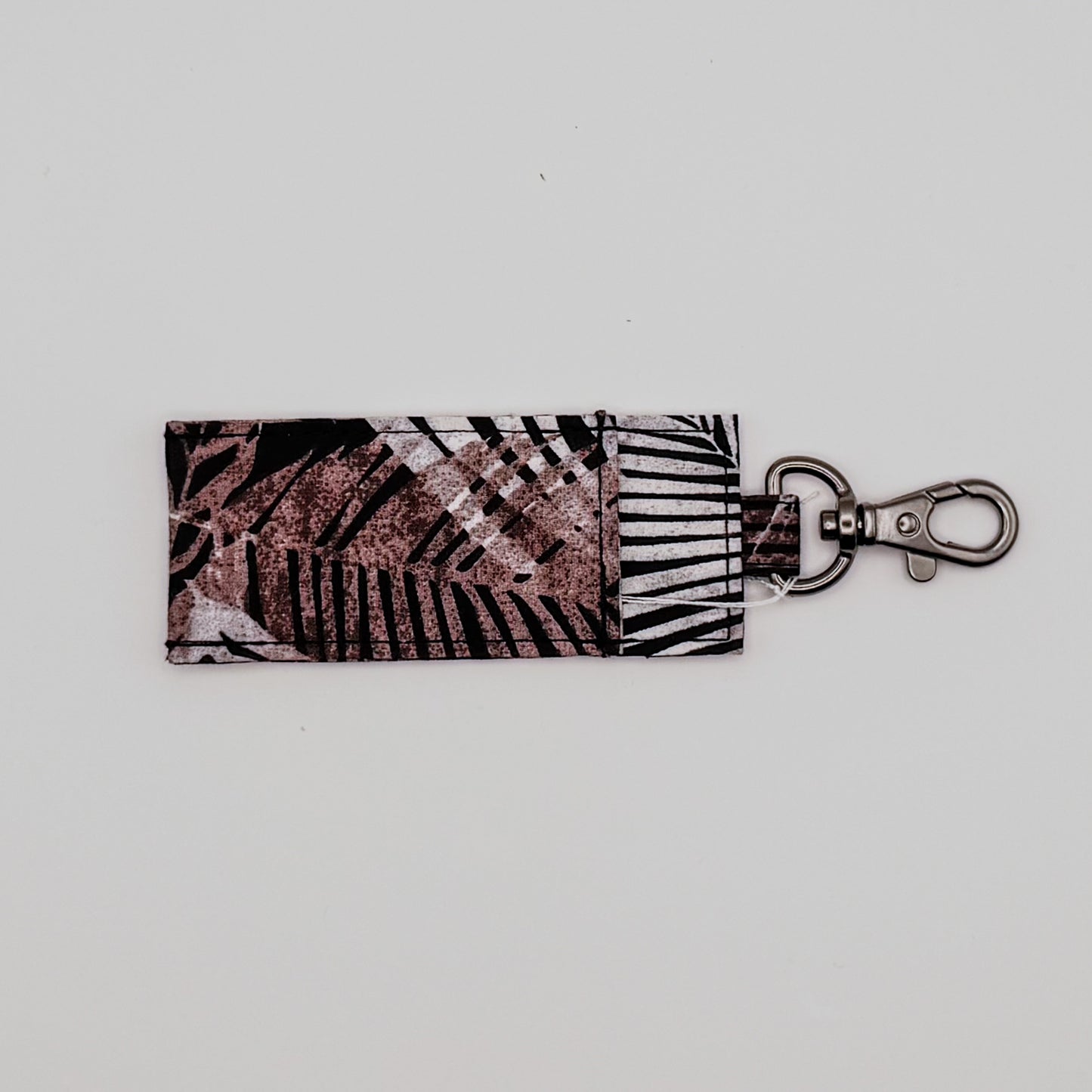 Keychain with leaf pattern on a light gray background