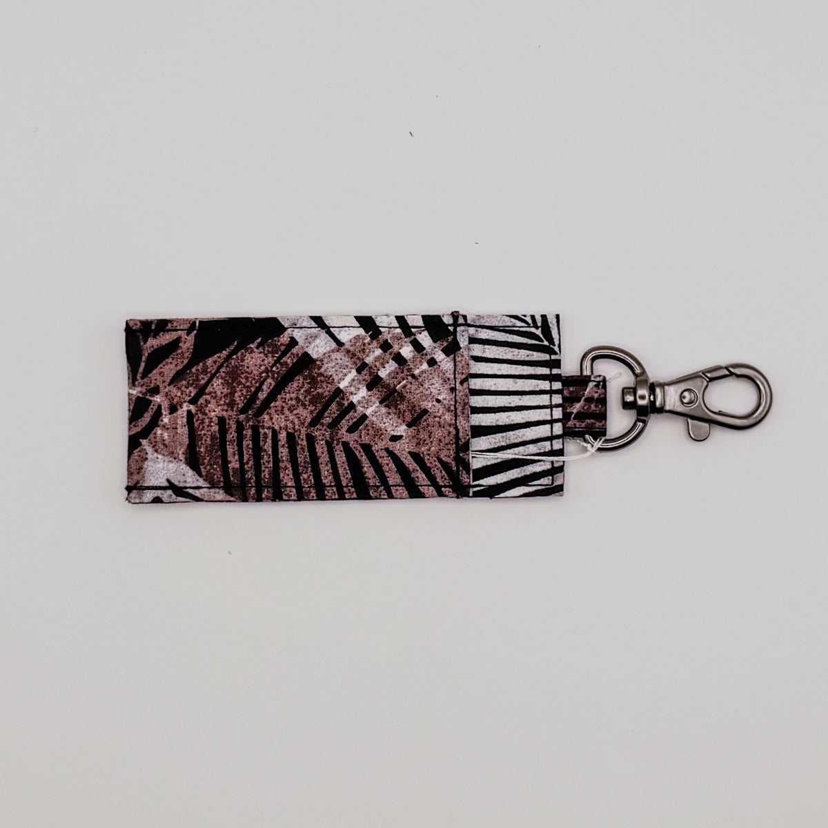 Keychain with leaf pattern on a light gray background