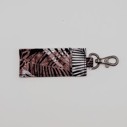 Keychain with leaf pattern on a light gray background