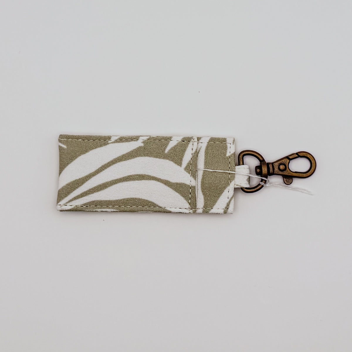 Fabric keychain with leaf pattern on a light gray background