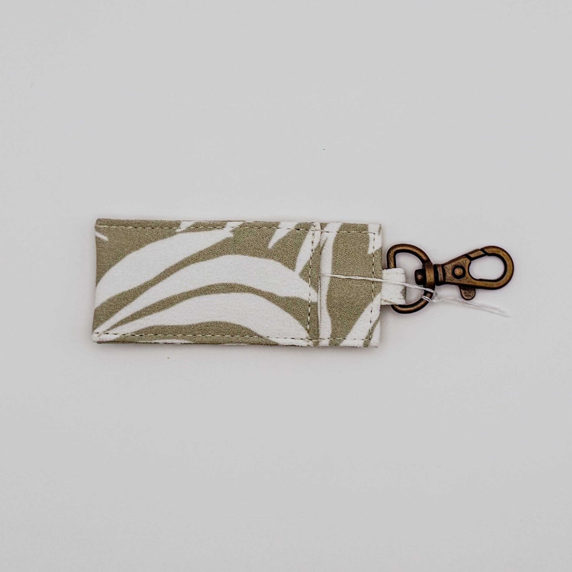 Fabric keychain with leaf pattern on a light gray background