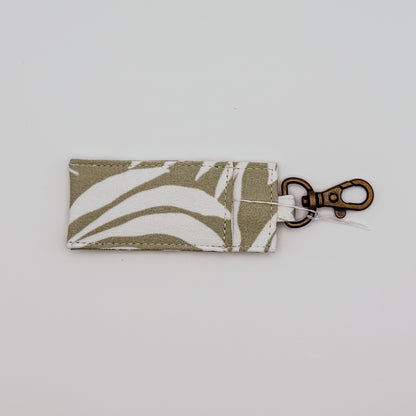 Fabric keychain with leaf pattern on a light gray background