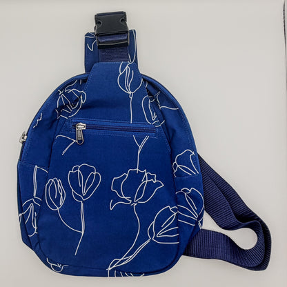Blue sling bag with floral pattern on a light gray background